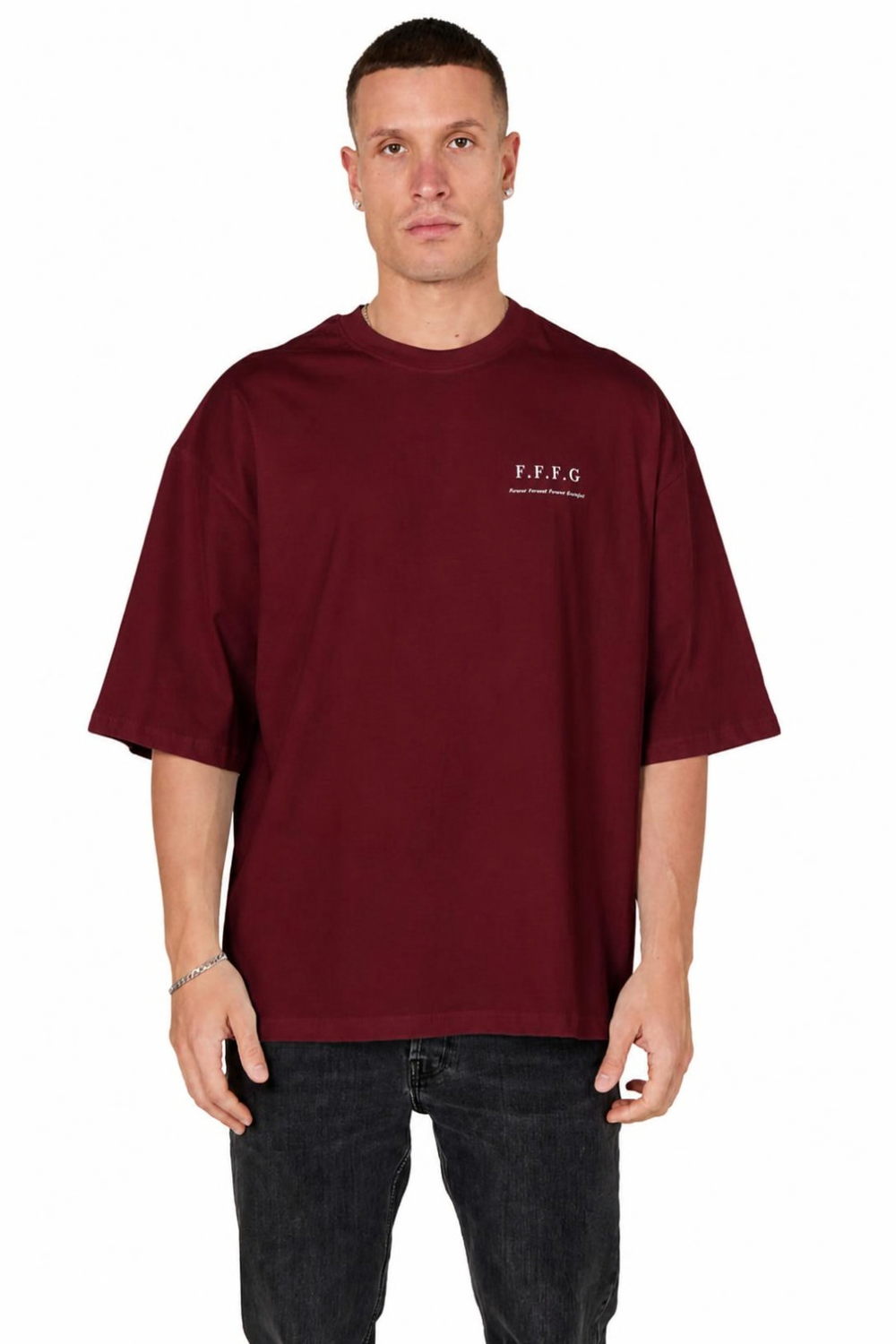 A man wearing an oversized maroon t-shirt with a small white 'F.F.