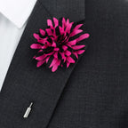 Black suit jacket with a bright pink flower lapel pin on a white background