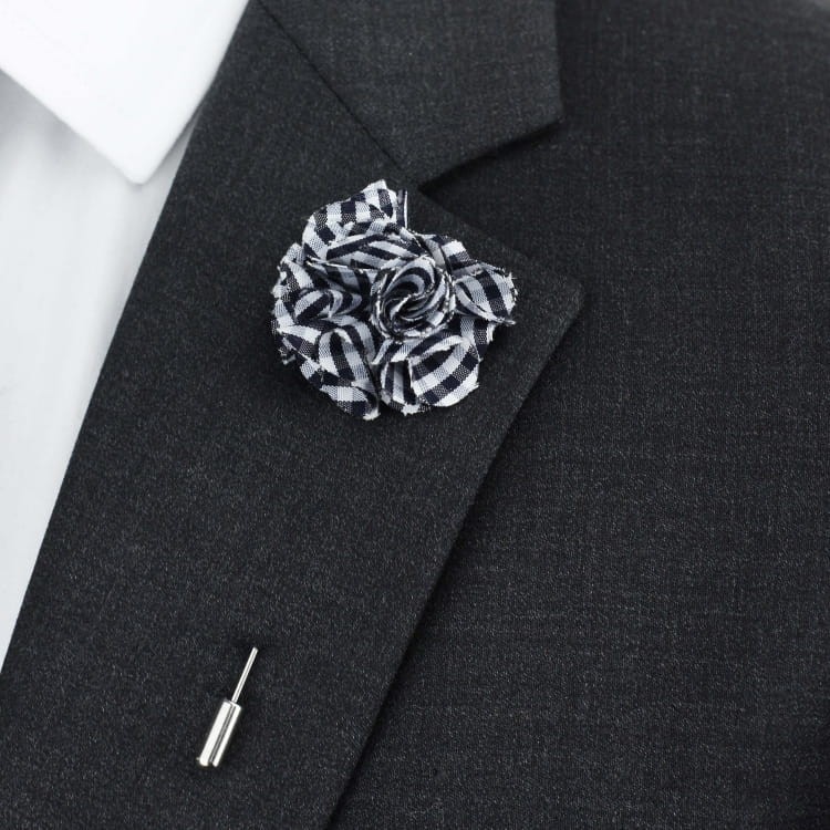 Black suit jacket with a black and white checkered lapel pin on a white background