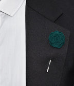 Green rose lapel pin on a black suit jacket