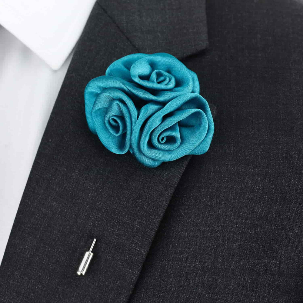 Turquoise rose lapel pin on a black suit jacket