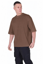 A man wearing a brown short-sleeve crewneck t-shirt and dark cargo pants, standing against a plain white background.