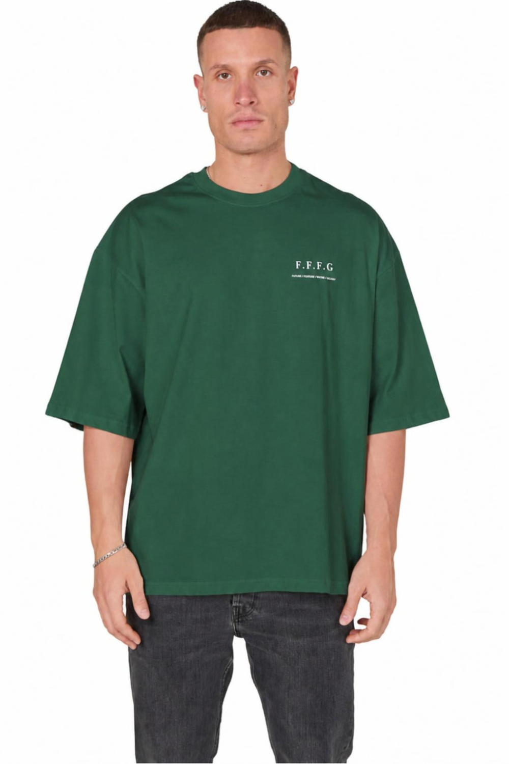 A man wearing an oversized dark green t-shirt with a small white 'F.F.