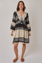 Woman wearing a black and white patterned dress on a plain background
