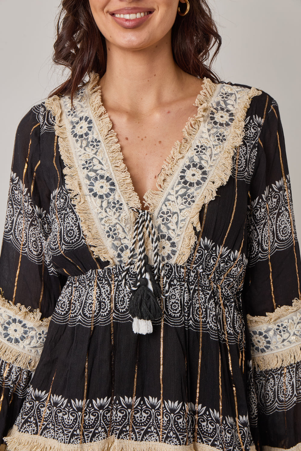 Woman wearing a black and white patterned dress with lace details.