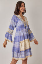 Woman wearing a blue and beige patterned dress on a plain background