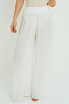White wide-leg pants worn by a person on a plain background