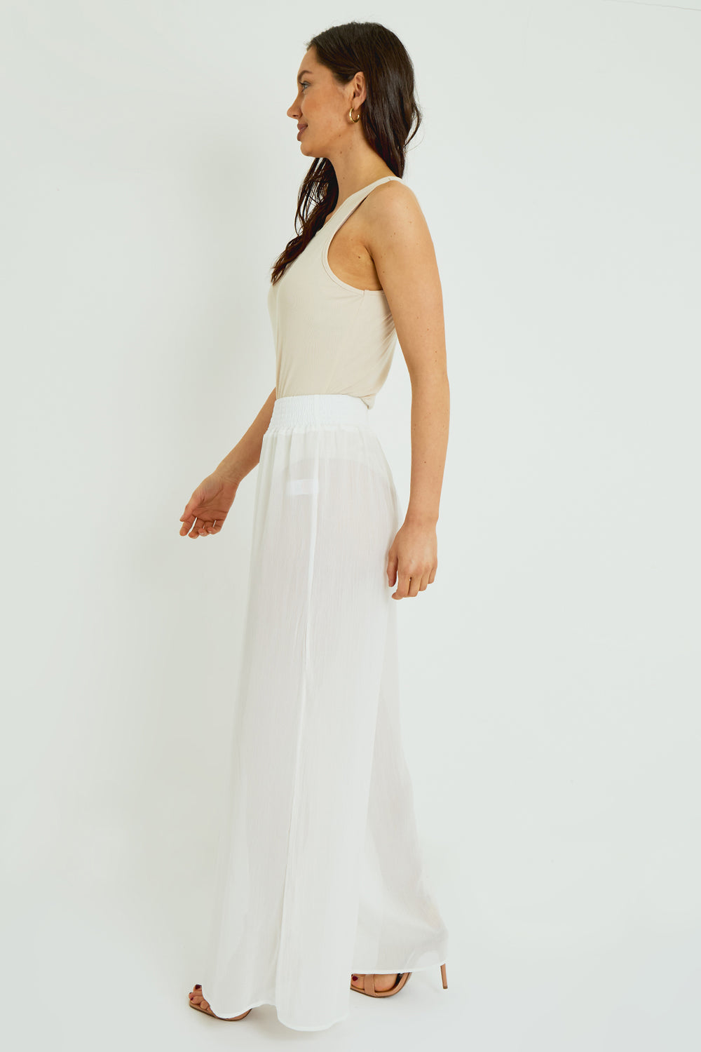 Woman wearing a white dress with a plain background
