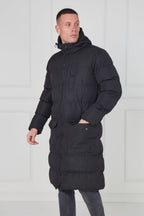 Man wearing a black puffer jacket against a white background