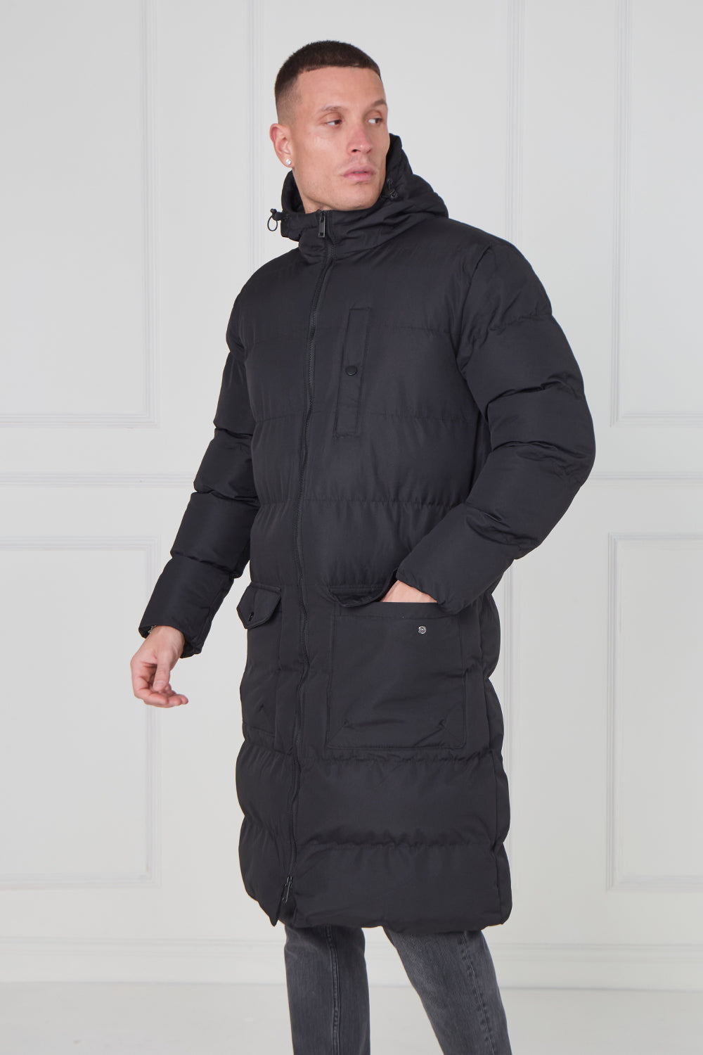 Man wearing a black puffer jacket against a white background