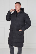 Man wearing a black puffer coat against a white background