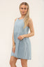 Woman wearing a light blue sleeveless denim smock dress made from 100% cotton, relaxed fit, casual summer outfit, UK size 8