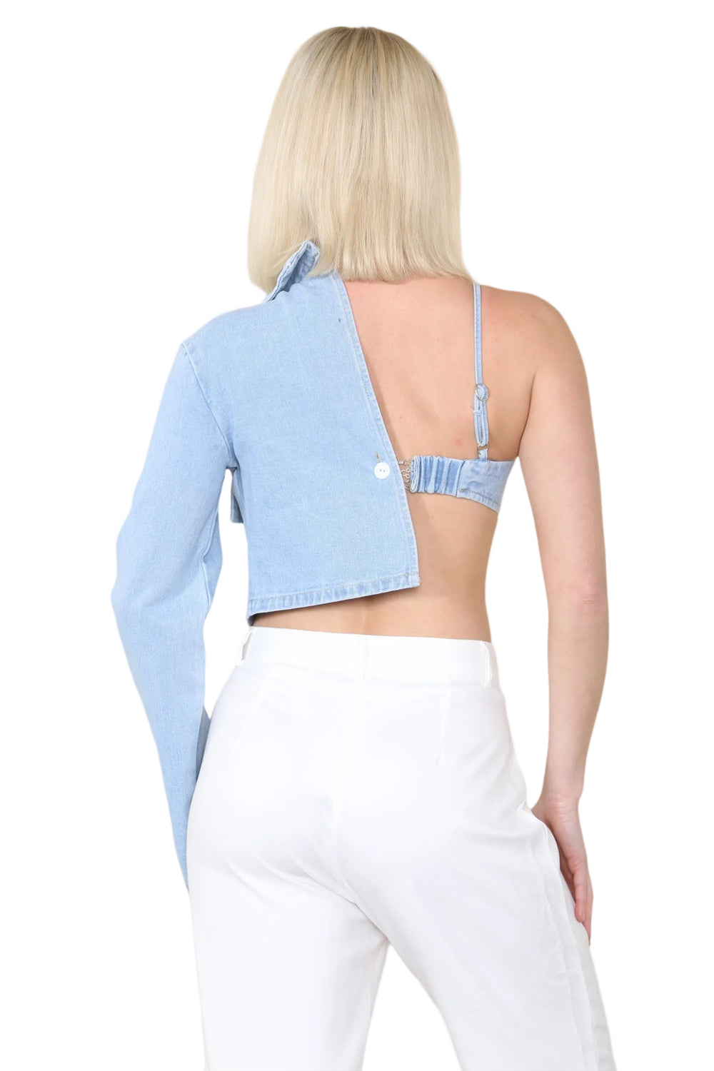 Woman wearing a light blue denim crop top with a unique cutout design on a beige background