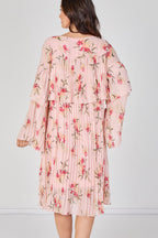 Woman wearing a pink floral dress against a white background