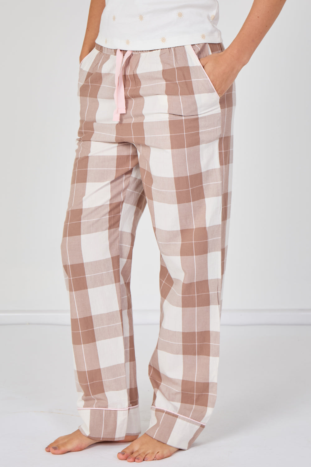 Plaid pajama pants worn by a person on a white background