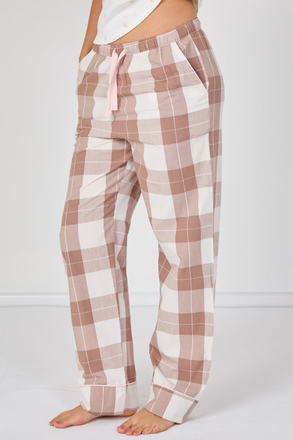 Plaid pajama pants with a pink drawstring on a white background